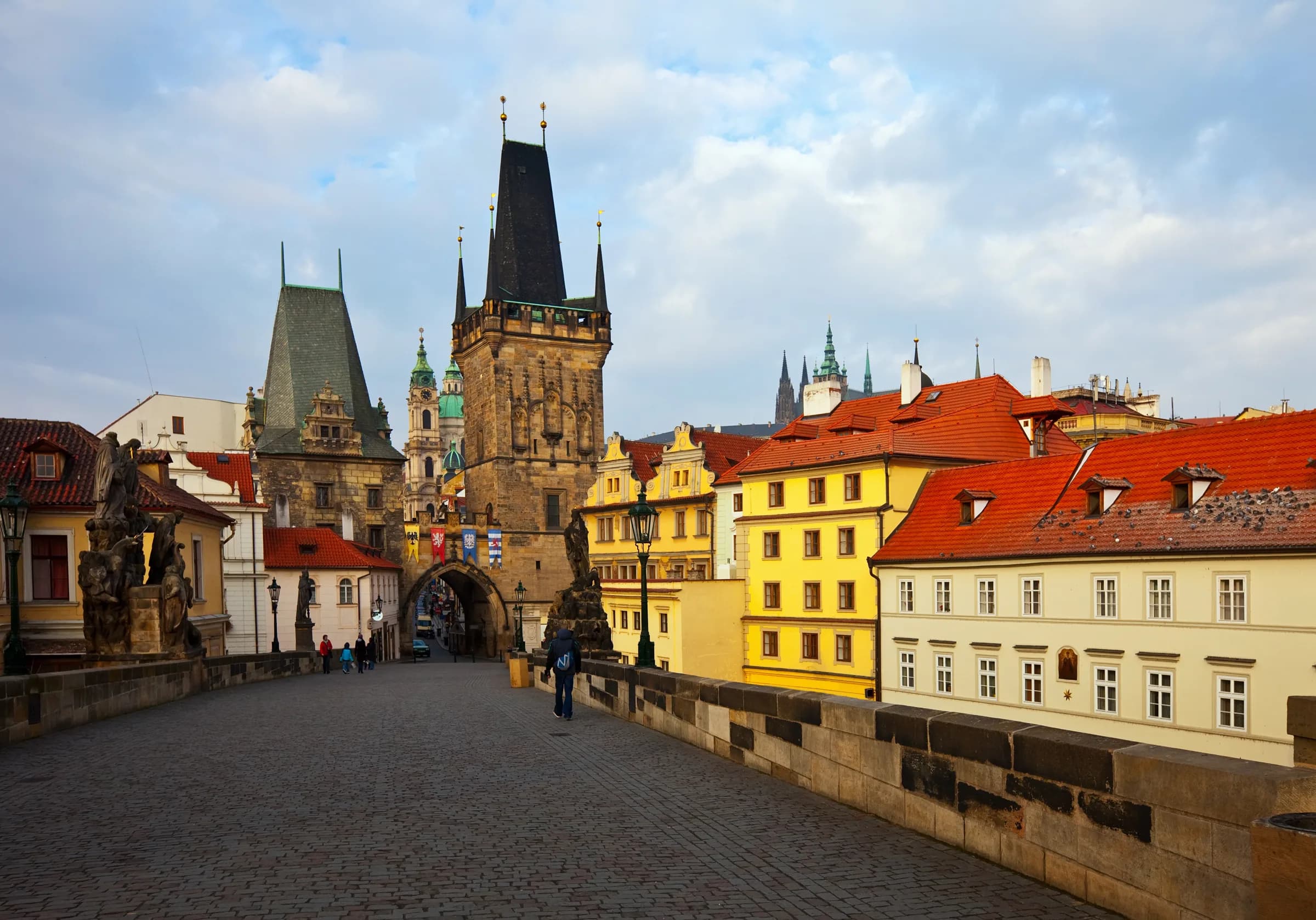 Charles Bridge in Prague, looking towards the bridge tower and red-roofed houses
